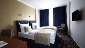 A hotel room with a bed, a desk, a chair, and a TV. - Central Hotel Pilsen (Plzen)
