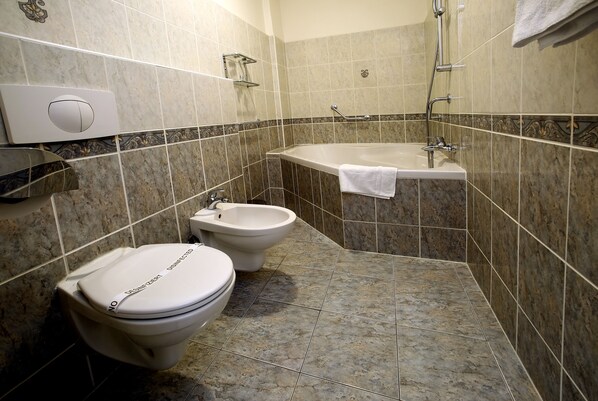 Un baño con inodoro, bidé y bañera.