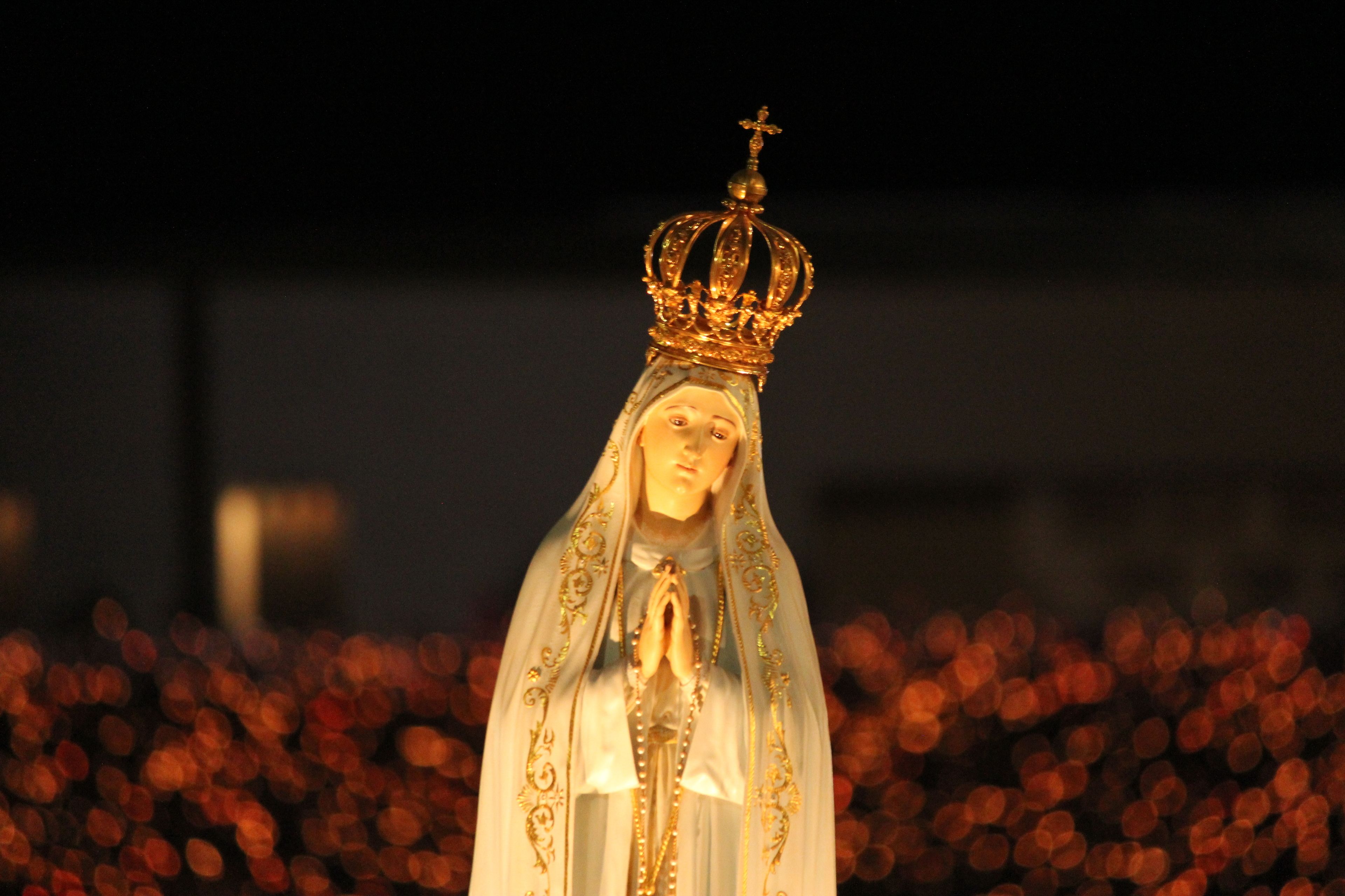 Una estatua con una corona y un velo, sobre un fondo desenfocado.