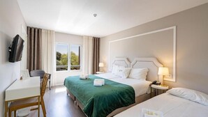 A hotel room with two beds, a desk, a chair, a TV, and a window with curtains. - Imperhotel by Umbral (Ourem)