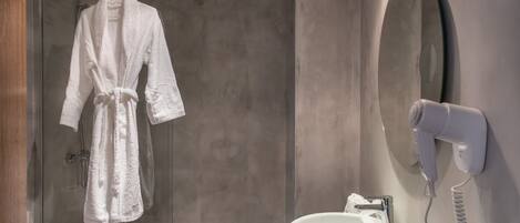 Un baño con una bañera blanca, un lavabo blanco con espejo y un secador de pelo en la pared.