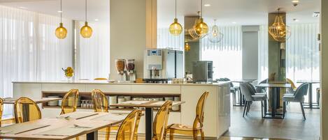 A modern dining area with a central island, clear glass chairs, and pendant lighting.