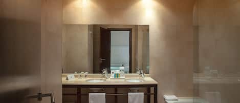 A modern bathroom with two sinks, a large mirror, a bathtub, and a shower.