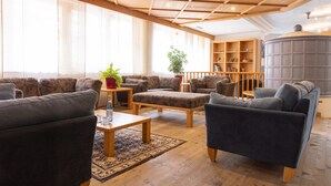Un amplio salón con suelo de madera, un ventanal grande y una estantería empotrada.