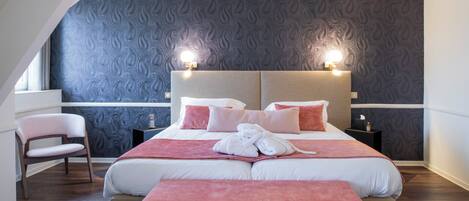 Una habitación de hotel moderna con una cama grande, dos mesitas de noche, una silla y un banco.