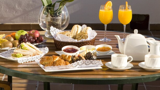 A breakfast table with food and drinks, overlooking a marina with boats and a view of the sea. - La Posada del Mar Hotel (Denia)