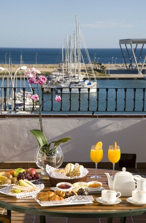 A breakfast table with food and drinks, overlooking a marina with boats and a view of the sea. - La Posada del Mar Hotel (Denia)