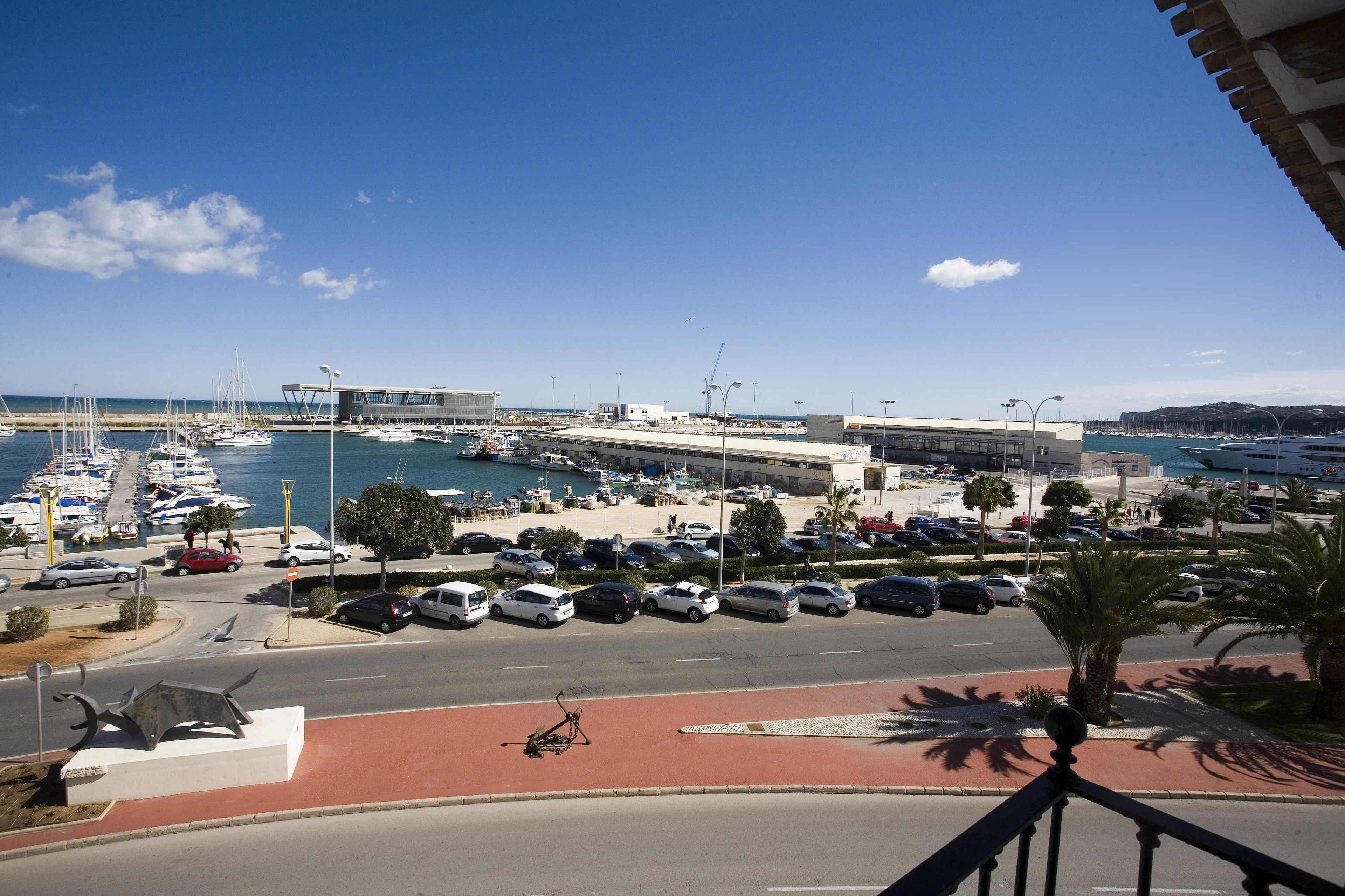 Un porto turistico con barche, un parcheggio e un edificio dal design moderno.