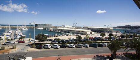 A marina with boats, a parking lot, and a building with a modern design.