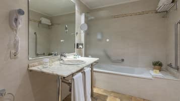 Une salle de bain moderne avec un lavabo en marbre, un sèche-cheveux portatif, une douche à l’italienne et une baignoire.