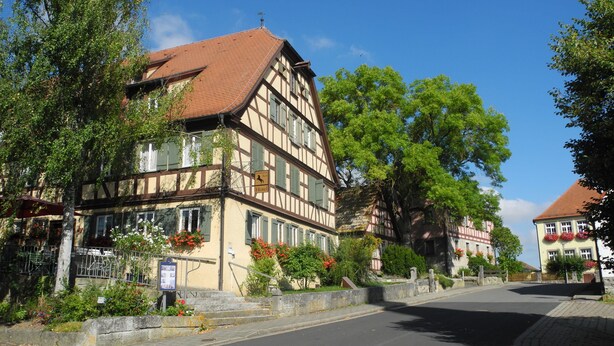 A traditional half-timbered building with a sign indicating it's a hotel. - Landhotel Schwarzes Ross (Steinsfeld)