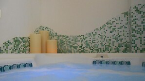 A hot tub with a tiled wall in the background. - Hotel Garni Lago Nembia (San Lorenzo Dorsino)