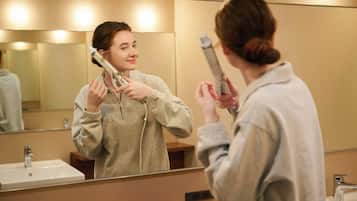 A bathroom with a sink, mirror, and a hairdryer.