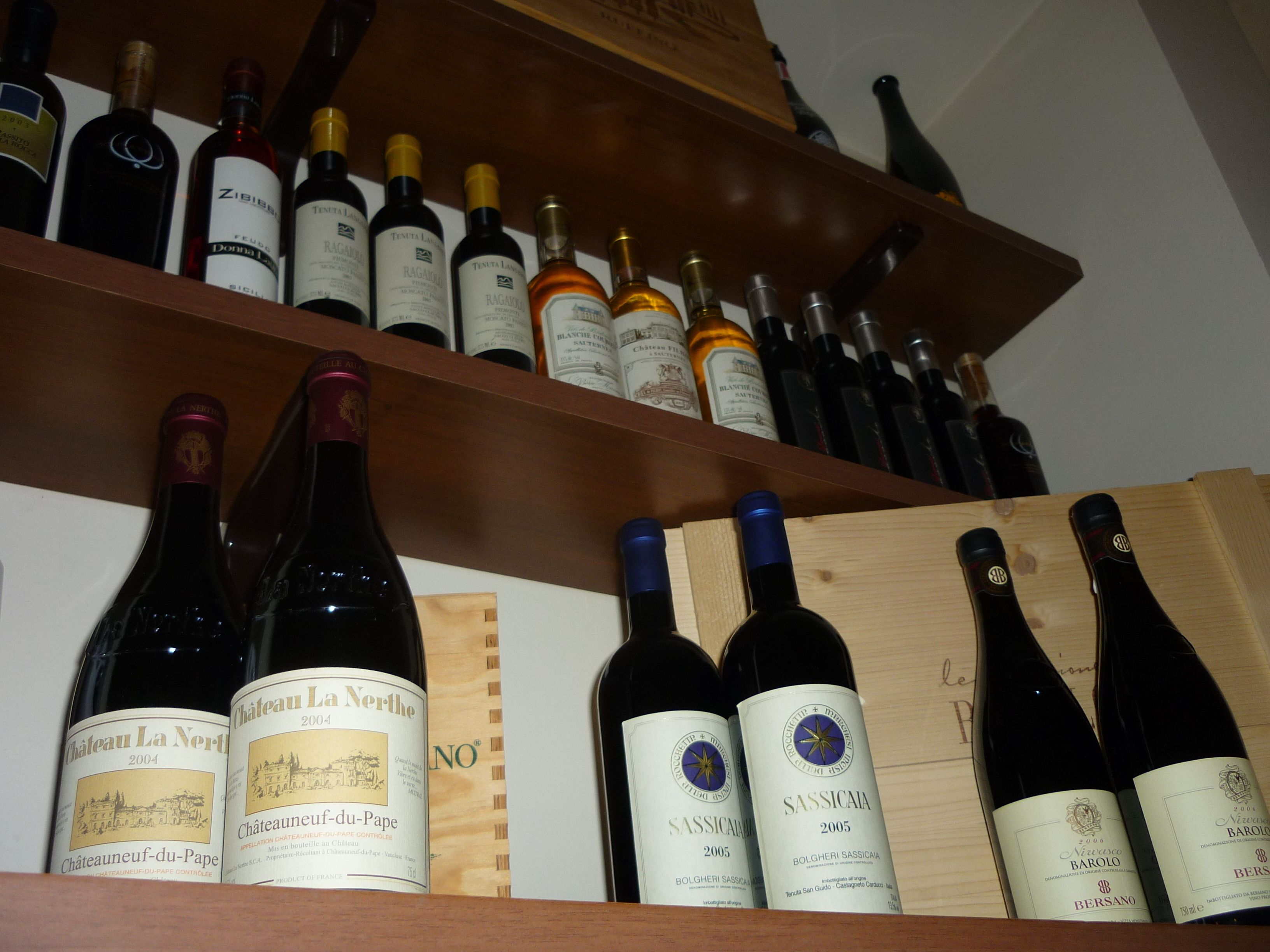 Varias botellas de vino sobre estantes de madera.