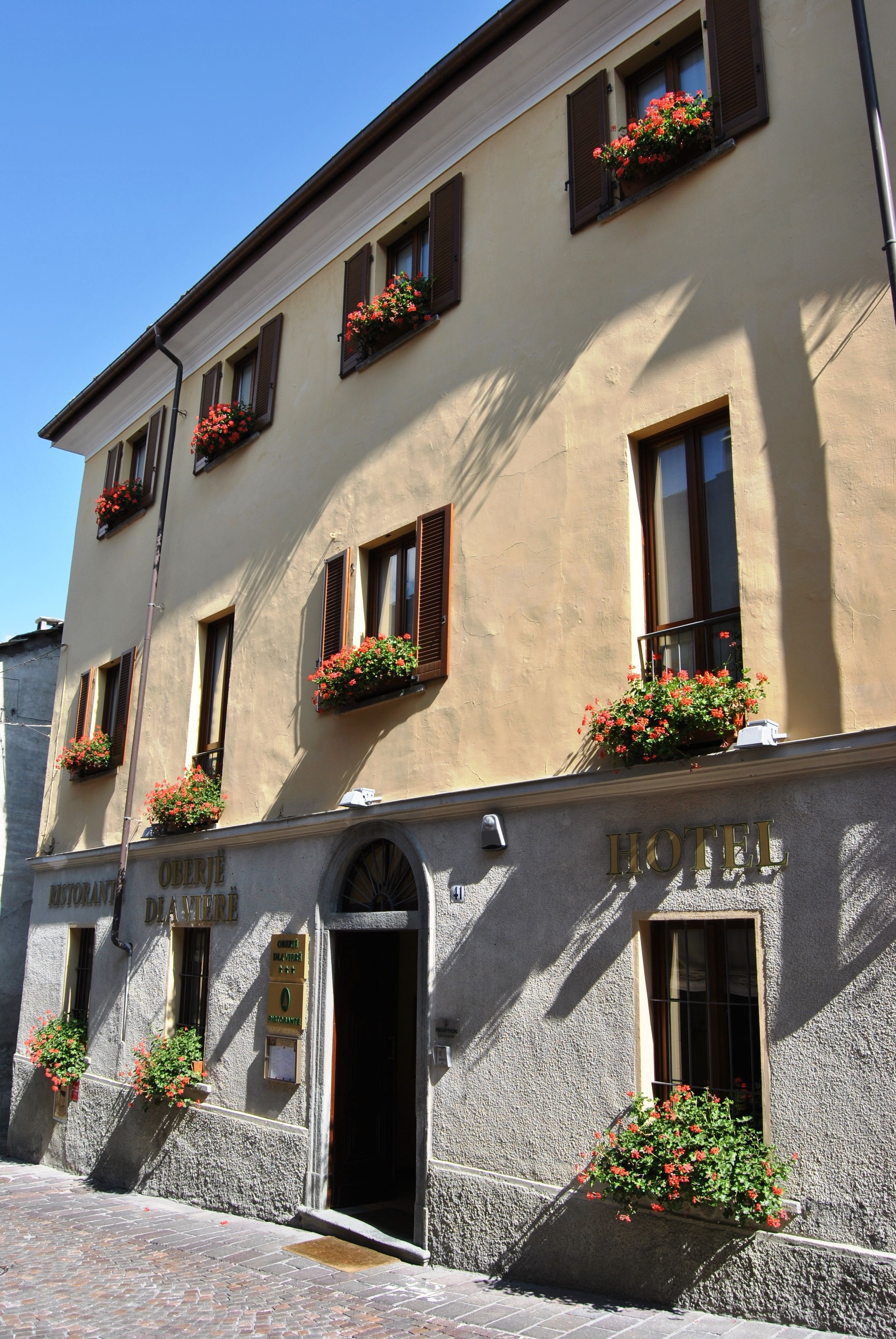 Un hôtel doté de nombreuses fenêtres, dont certaines sont ornées de jardinières.