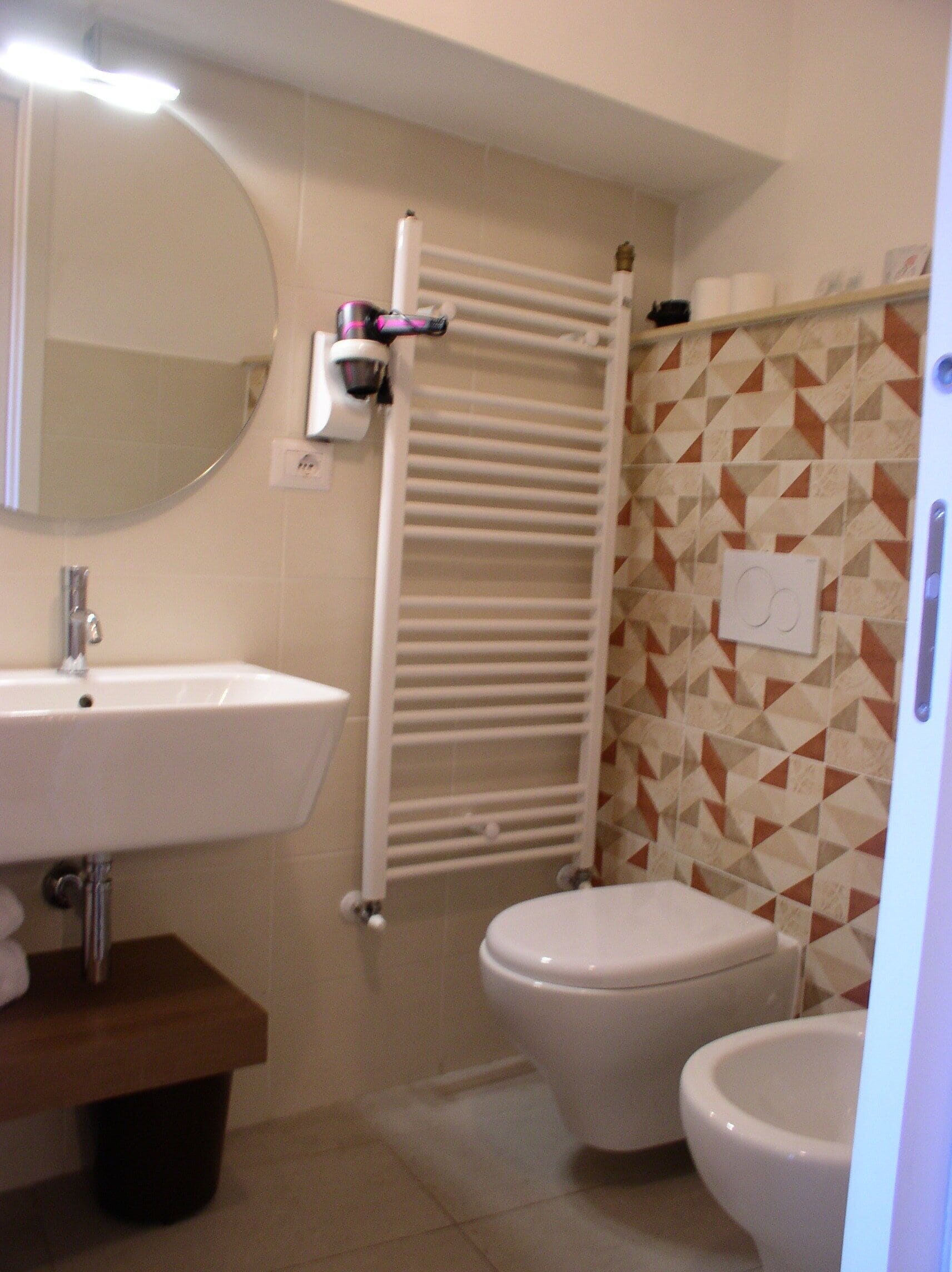 A bathroom with a sink, toilet, and towel rack.