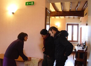 A room with a wooden ceiling, a map on a table, and a green exit sign on the wall.
