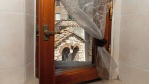 A wooden door with a glass panel, a metal handle, and a decorative iron keyhole.