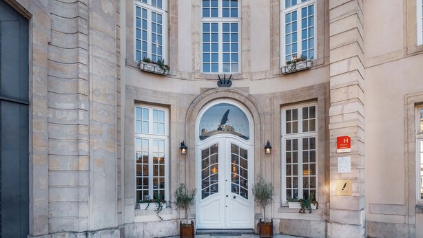 A historic building with a central arched entrance, multiple windows, and a plaque. - Hôtel Littéraire Stendhal et Spa (Nancy)