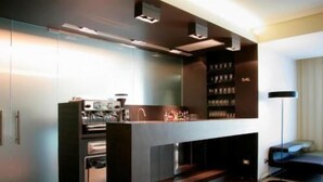 A modern kitchen with built-in appliances, a central island, and a bookshelf. - Art Hotel Udine (Udine)