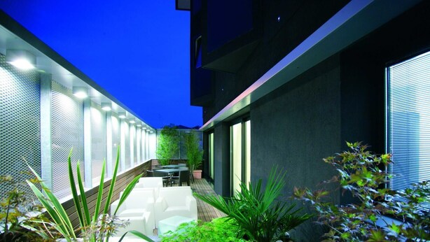 A modern outdoor patio with a seating area and plants. - Art Hotel Udine (Udine)