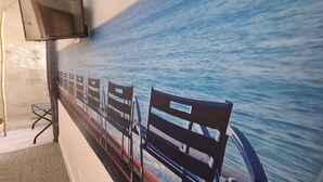 Un pasillo con filas de sillas de madera y un mural en la pared que representa una masa de agua.