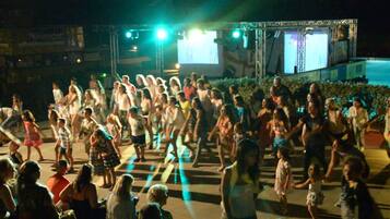 Ein lebhaftes Open-Air-Event mit Bühne und großen Bildschirmen.