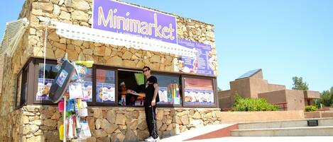 A stone building with a sign reading "Minimarket."