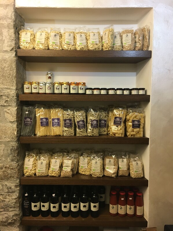 A shelf with various pasta and sauces.