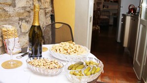 A table with a bottle of wine, snacks, and a glass. - Casa Mario Lupo (Bergamo)