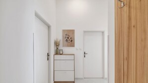 Un pasillo con un armario de madera, una puerta y una obra de arte en la pared.