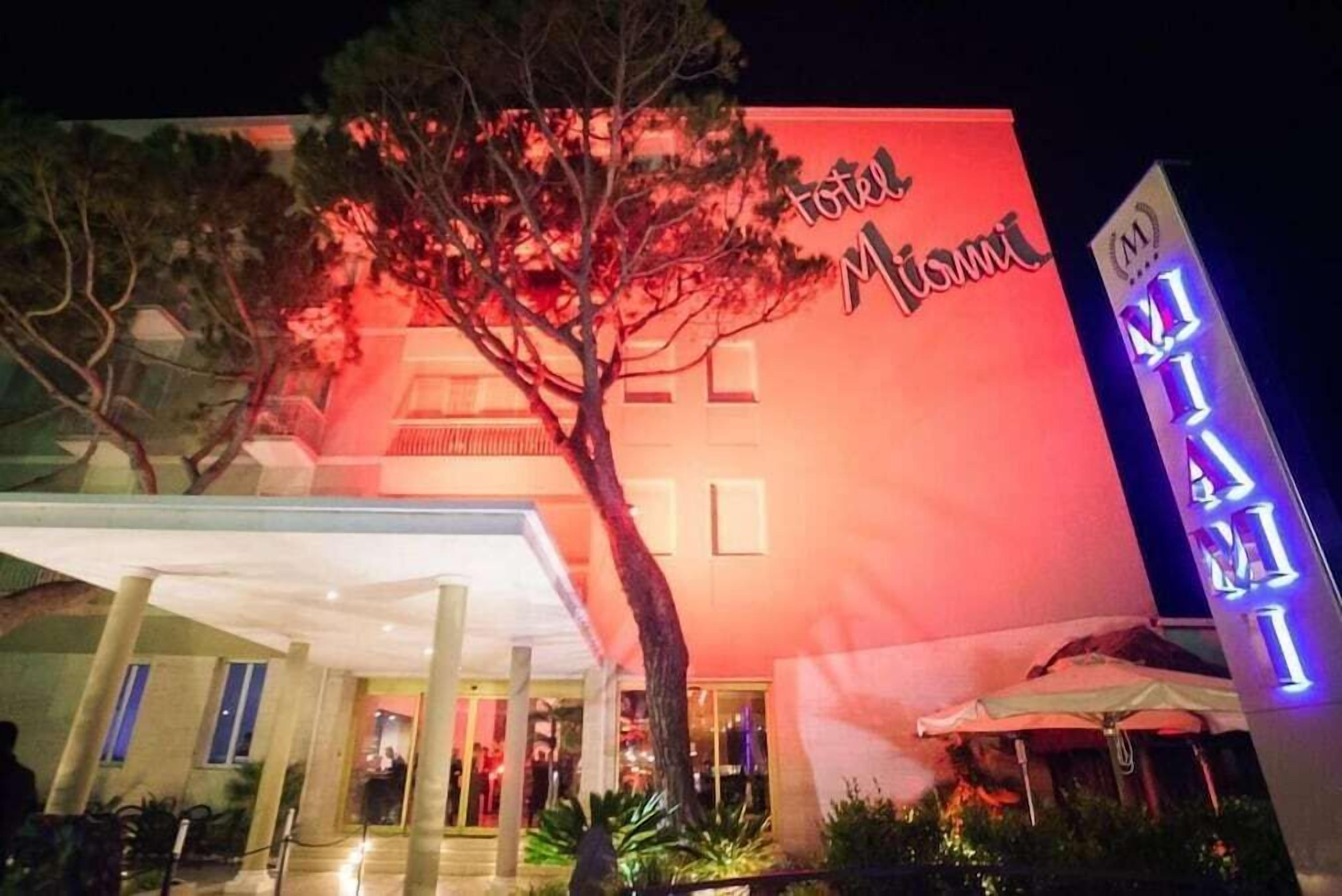 A hotel with a prominent red facade and a sign that reads "Hotel Miami."