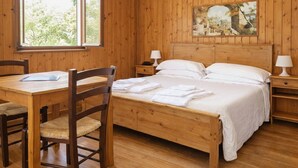 A wooden room with a bed, a desk, and a chair. - Garden Village San Marino (Borgo Maggiore)