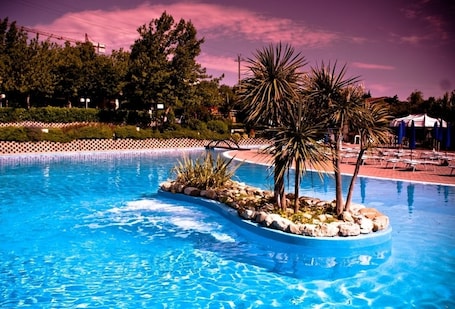 Una piscina al aire libre de temporada, sombrillas