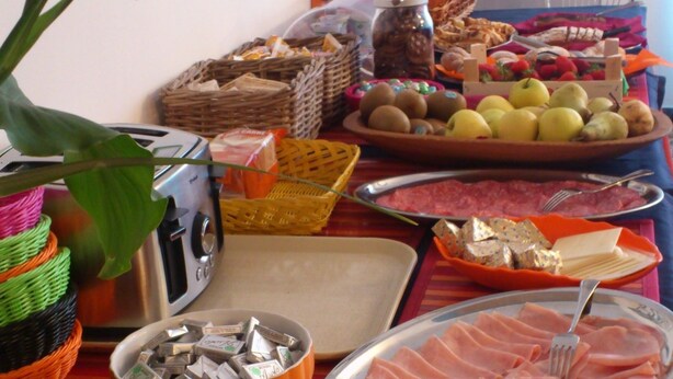 A buffet table with various food items, including fruits, cheeses, and meats. - Hotel Villa Elia (Rimini)