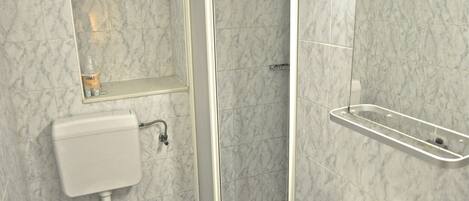 A bathroom with a toilet, sink, and shower.