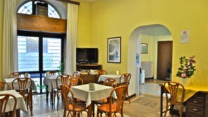 A dining area with tables and chairs, a television, and a framed picture on the wall. - Hotel Vecchia Milano (Milan)