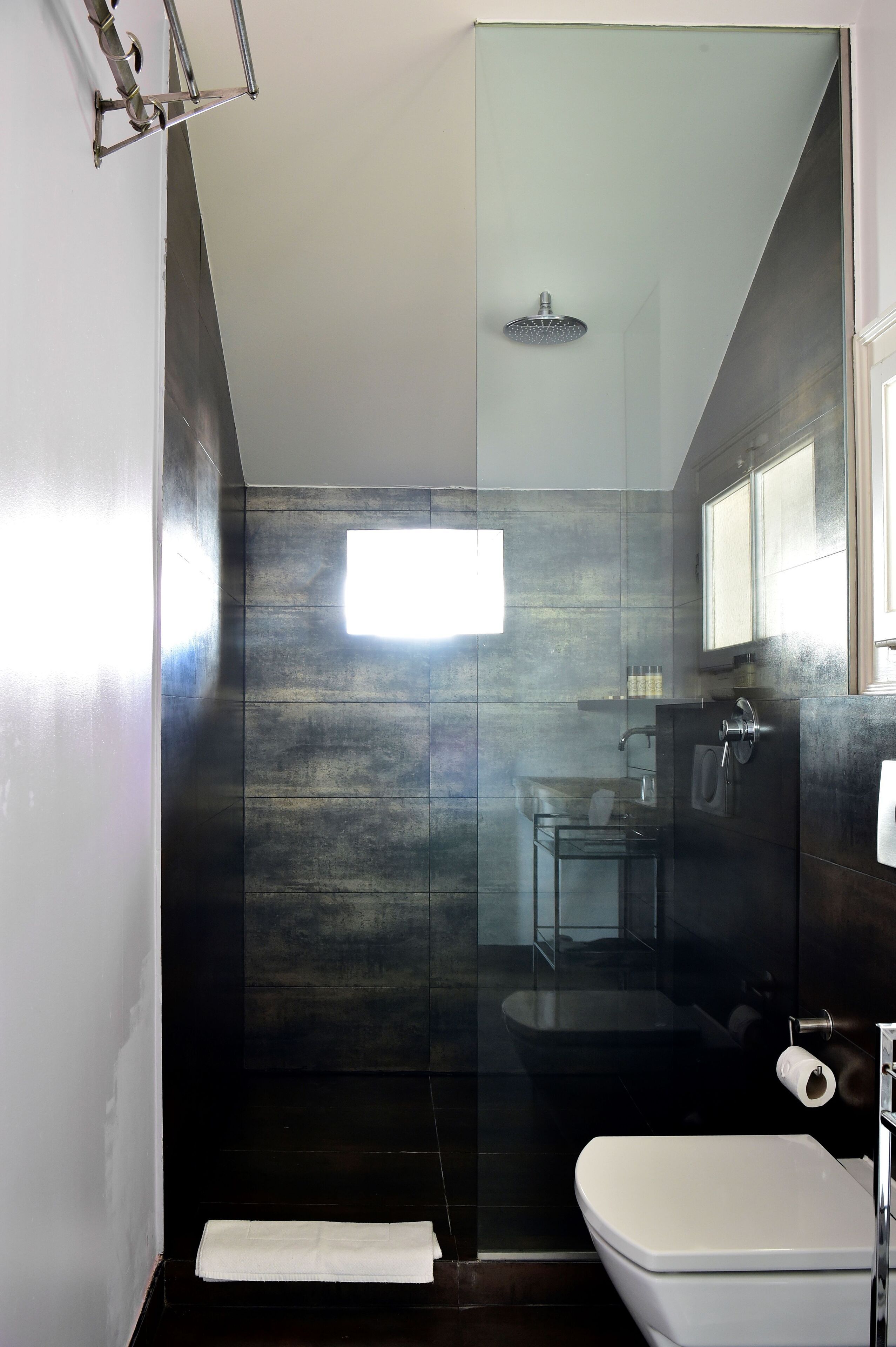 Un bagno moderno con cabina doccia in vetro, un water bianco e un lavandino in vetro.