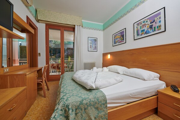 A bedroom with a bed, wooden nightstand, dresser, and a chair.