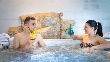 Relax in the hotel's hot tub, surrounded by a beautifully designed space with a small table and amenities at your fingertips.