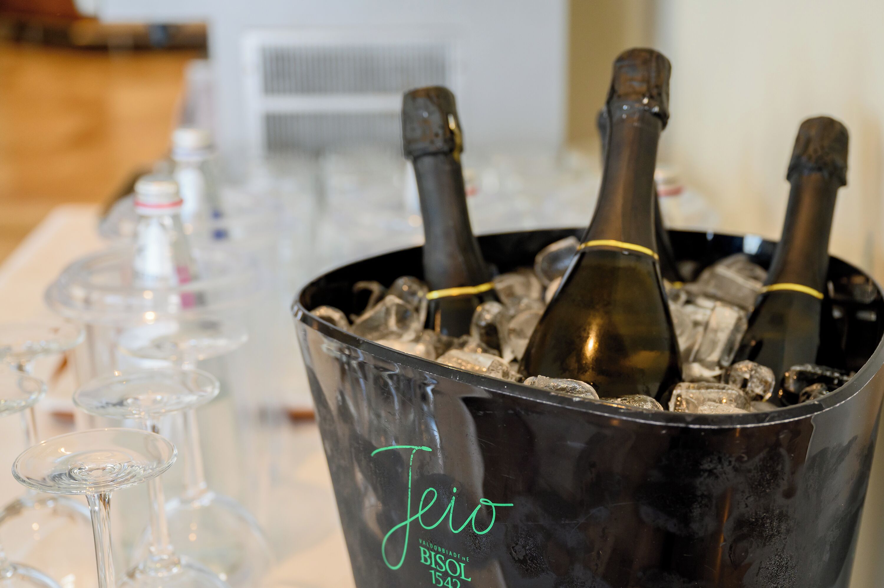 A bucket filled with ice and two bottles of wine, labeled 'Jeio BISOLO 1542'.