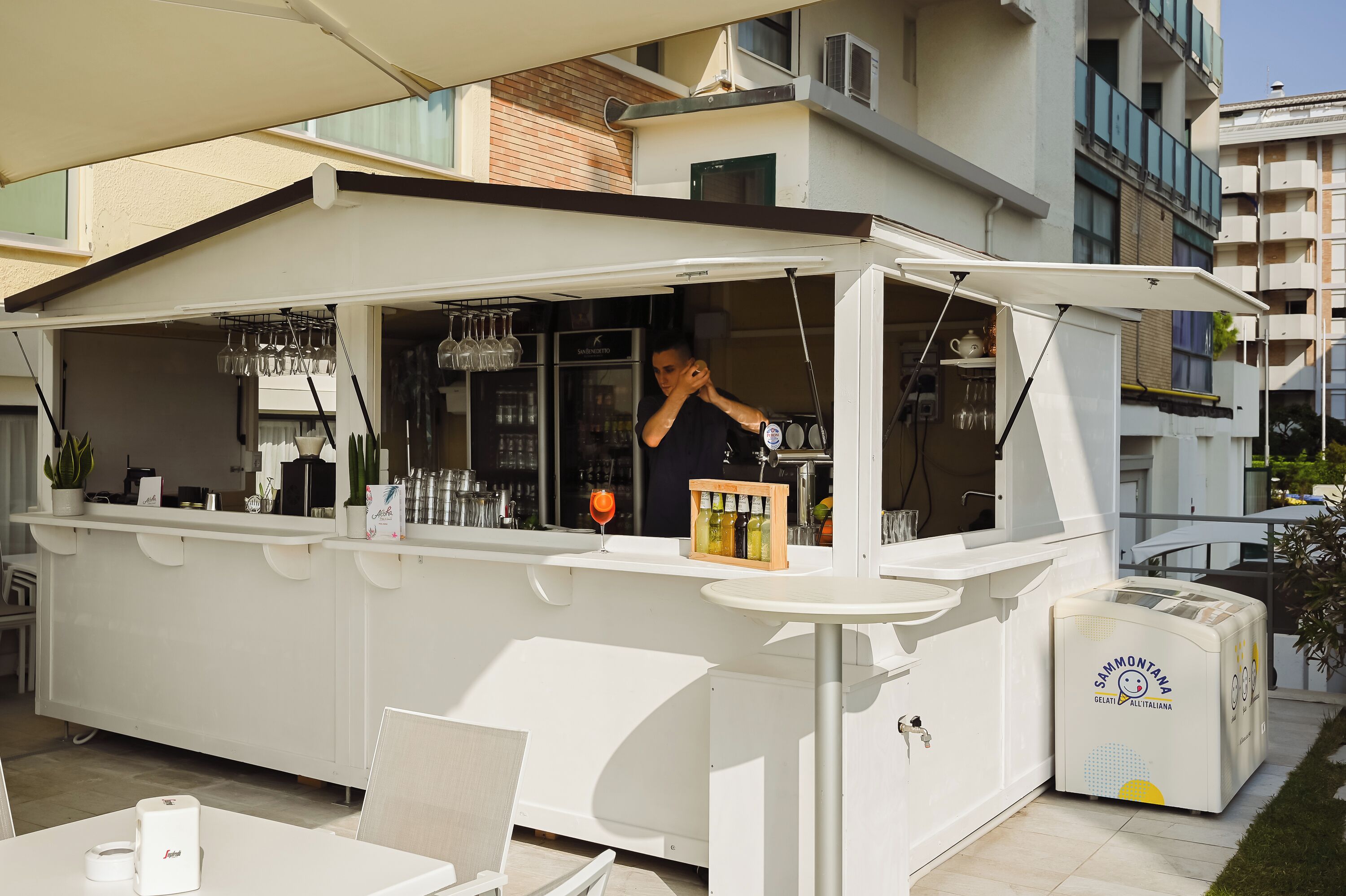Un espace bar extérieur comprenant un comptoir, des sièges et un réfrigérateur.
