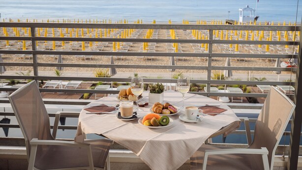 Une table dressée pour le petit-déjeuner, avec vue sur la plage et l’océan.