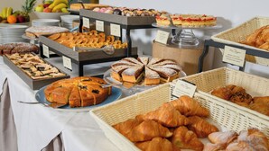 Un buffet proposant une variété de viennoiseries, de gâteaux et de fruits.
