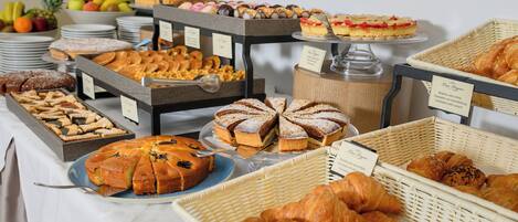 Un bufé con diversos pasteles, tartas y frutas.