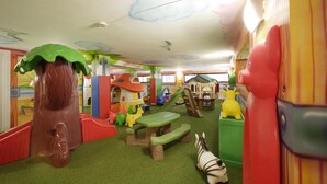 A children's play area with various play structures, including a slide, climbing wall, and a playhouse. - Hotel Gardenia (Jesolo)