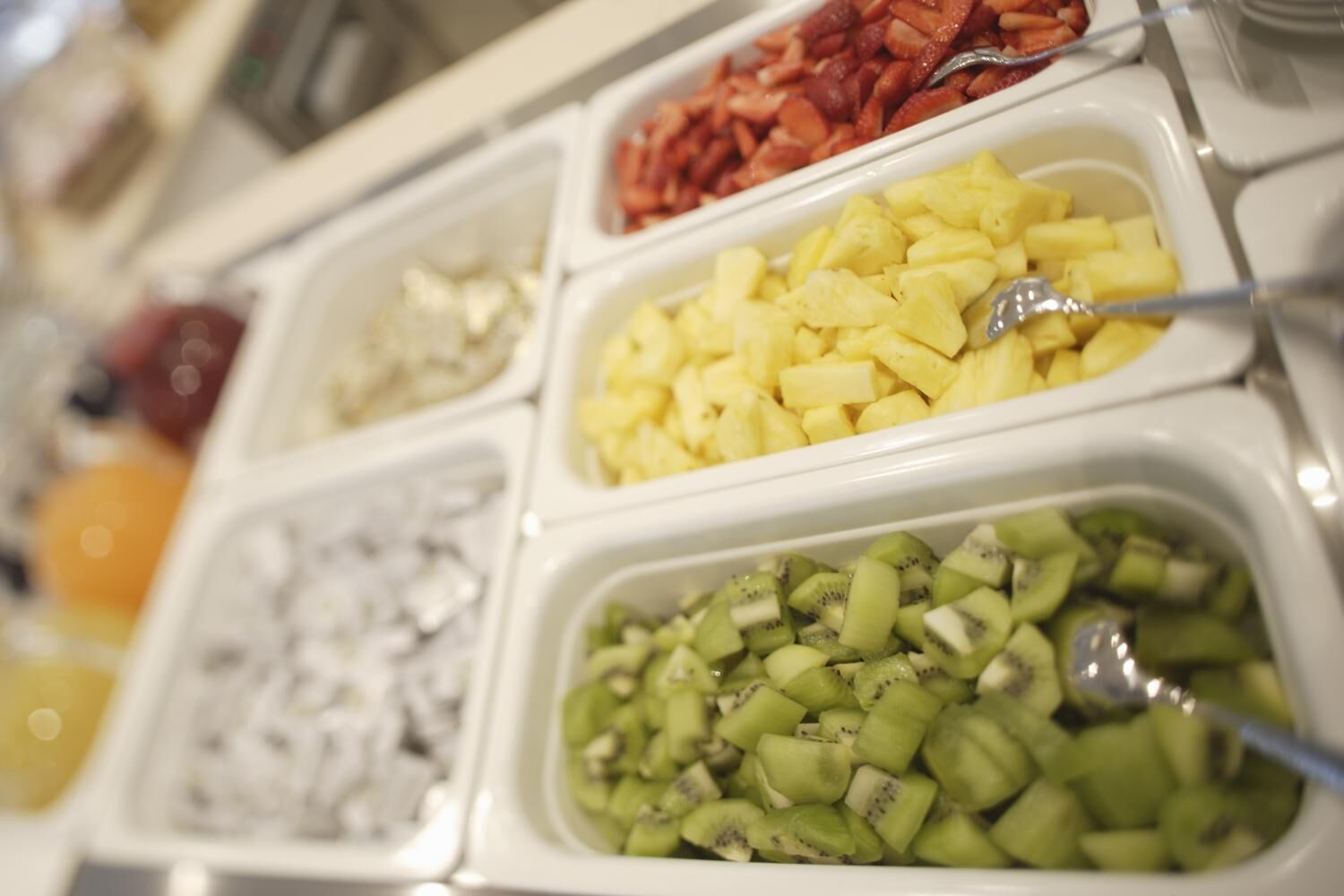 A buffet with various food options including fruits and meats.