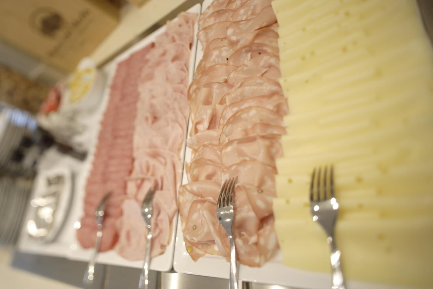 A display of sliced meats on a table with forks.
