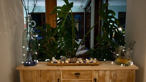 Un mueble de madera con varios cajones y un jarrón de cristal con luces decorativas en la parte superior.