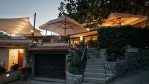Un edificio con terraza, escaleras y plantas en macetas.